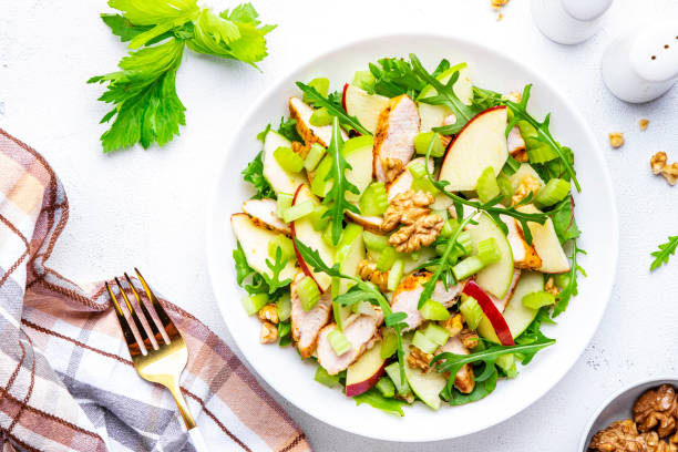 istock Old fashioned salad with chicken, red and green apples, raw celery, lettuce and walnuts, white background, top view 2168441426