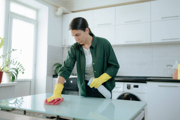 istock Serious Housewife Cleans Kitchen Table in Protective Gloves 2168441810