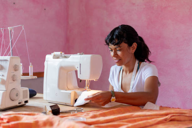 istock seamstress or small business owner using smartphone and debit card at workshop 2168449988