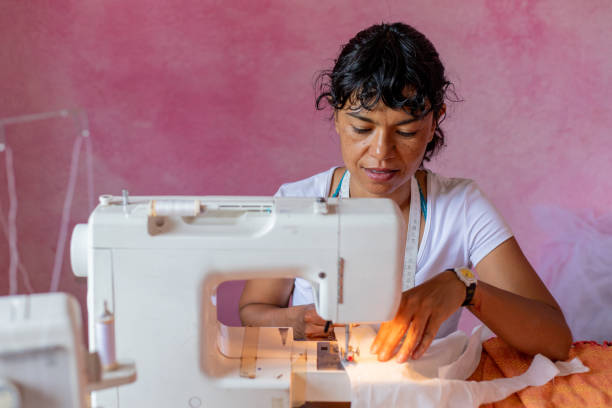 istock seamstress or small business owner using smartphone and debit card at workshop 2168449989