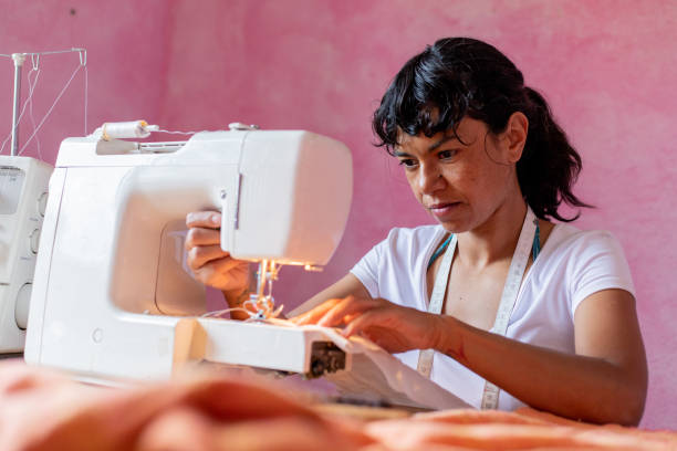 istock seamstress or small business owner using smartphone and debit card at workshop 2168450057