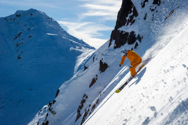 Man skis steep slope at ski resort in fresh powder snow, Whistler, B.C.