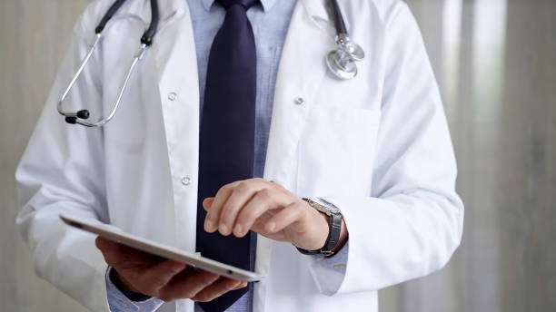 istock Doctor man wearing lab coat and stethoscope using tablet computer in hospital. Medicine and science 2168453360
