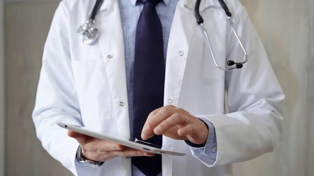 istock Doctor man wearing lab coat and stethoscope using tablet computer in hospital. Medicine and science 2168453805