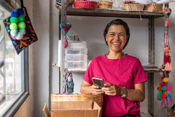 istock woman using smartphone and mobile app at her small craft business 2168455922