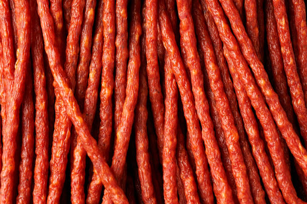 Tasty kabanos pork and herbs sausages on rustic stone board.