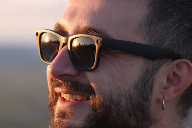 istock Man smiling while taking video or photo with his smart glasses outdoors 2168461543