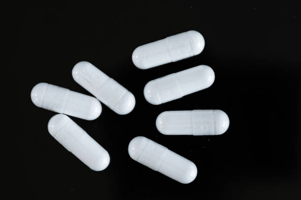 Capsules of magnesium supplement on a black background