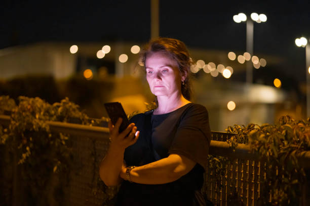 istock woman using mobile phone in outdoor setting, at evening 2168463862