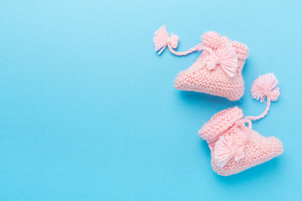 istock Pink baby booties on color background, top view 2168464174