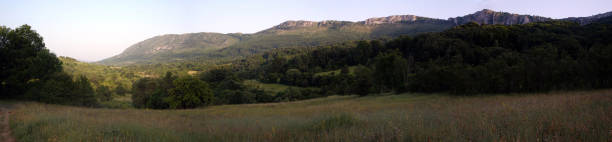 istock Panorama of a mountain range and forest in a valley on a summer day 2168480038