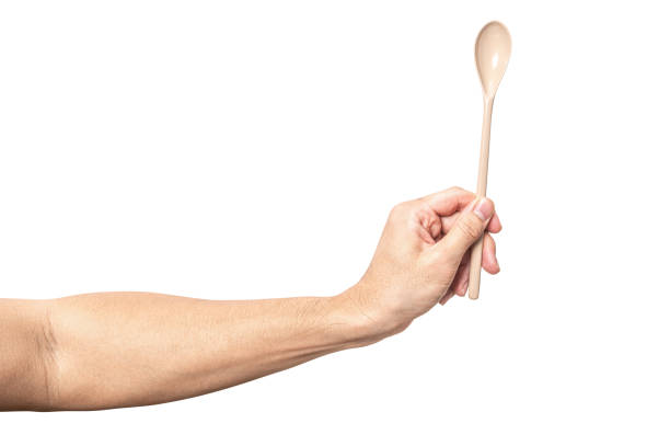 istock Male hand holding a brown plastic spoon isolated on white background. 2168484836