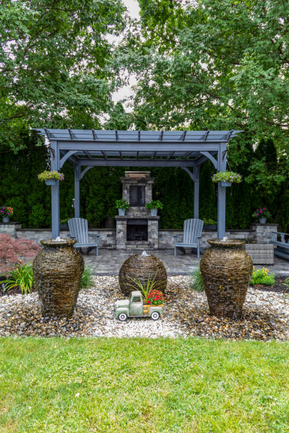 istock Large gray pergola on pavers with stone fireplace and waterfall urns for backyard oasis landscape design 2168487241