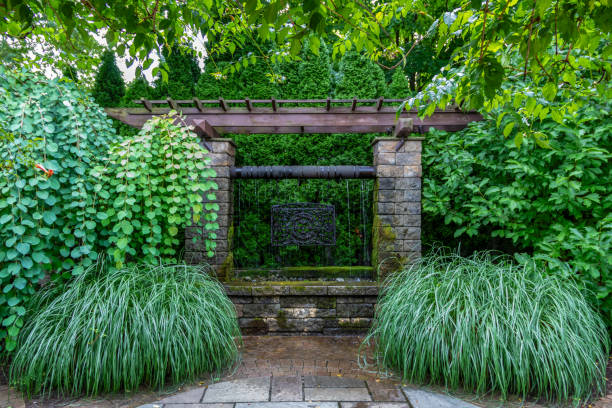 istock Stone pergola with waterfall and ornamental grasses backyard oasis landscape design 2168487247
