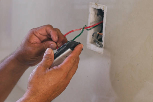 istock Hands of electrician screwing a plate for the socket 2168491779