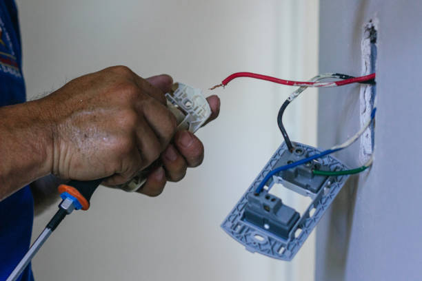 istock Hands of electrician screwing a plate for the socket 2168491805