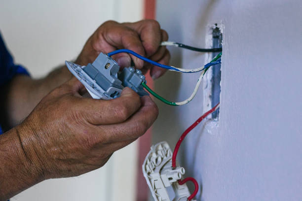 istock Hands of electrician screwing a plate for the socket 2168491813