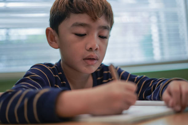 istock Child boy writes on his homework book 2168495807