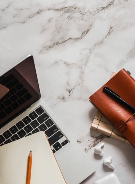istock Laptop, notebook, headphones on a marble table, top view. Business, education, study concept 2168497566
