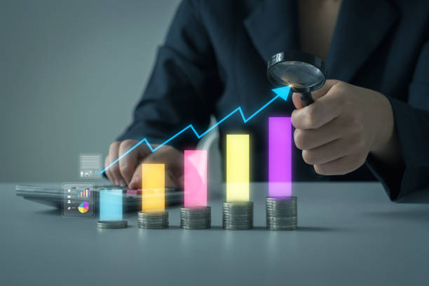 istock Digital marketing, Data analysis for performance. Business professional using magnifying glass analyze financial growth represented by digital charts and stacked coins, indicating investment success 2168498395