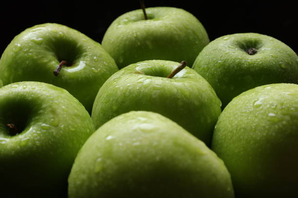 Closeup of green apple fruit with drops water background