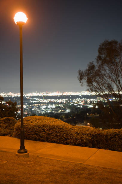 A yellow lamp lighting a pedestrian path at Hilltop Park in Signal Hill CA, overlooking Los Angeles county.
