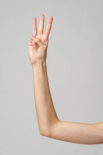 istock A Woman's Hand Showing Three Fingers Against a Gray Background 2168506869