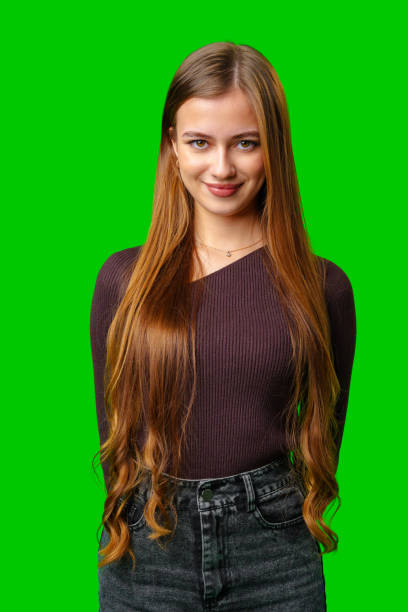 istock Smiling Young Woman Posing In Front Of Green Screen 2168506876