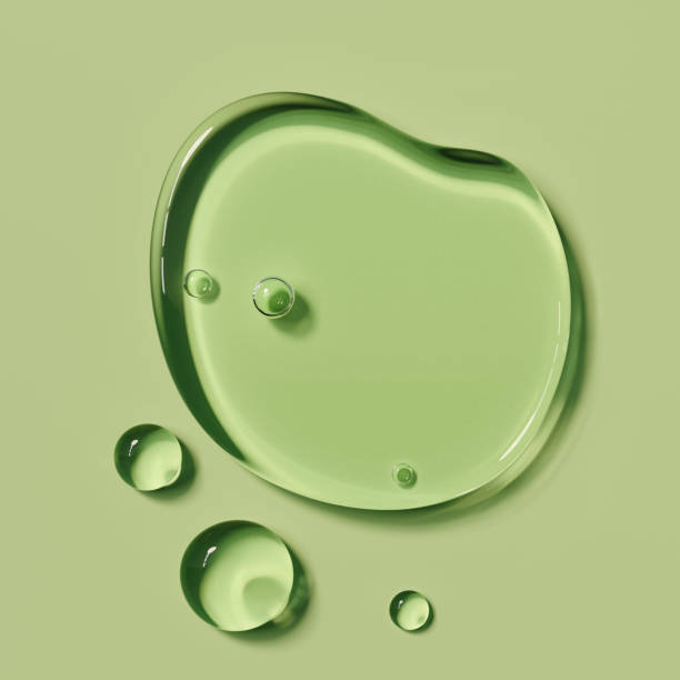 Beauty product Serum liquid sample round shape drops on green background,