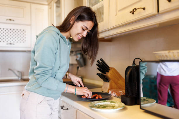 istock Young woman preparing meal at home 2168515133
