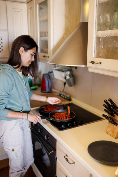 istock Young woman preparing meal at home 2168515280