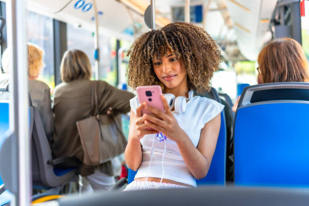 istock Young woman using phone distracted sitting on public bus 2168516181