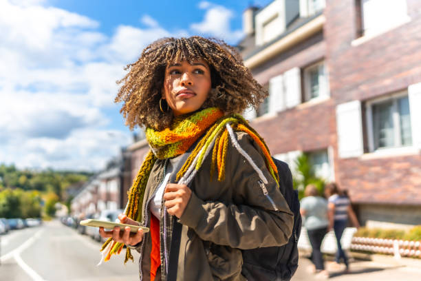 Distracted young woman using phone in the city
