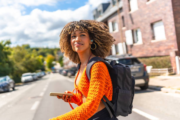 istock Latin woman walking along street using mobile phone 2168516270
