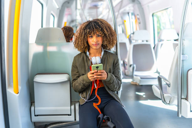 istock Latin woman sitting on the train using phone 2168516331