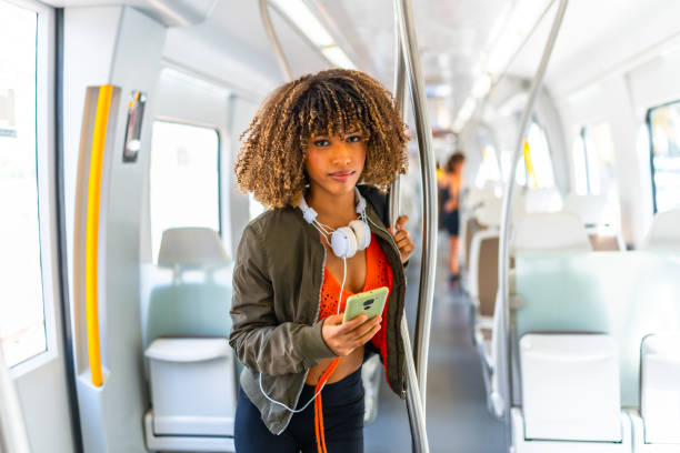 istock Young woman standing on the metro while using phone 2168516335