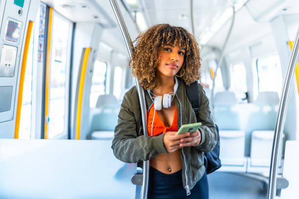 istock Latin woman standing on the train using cellphone 2168516339