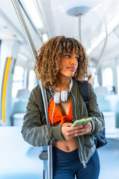 istock Confident latin woman using phone standing on the train 2168516341