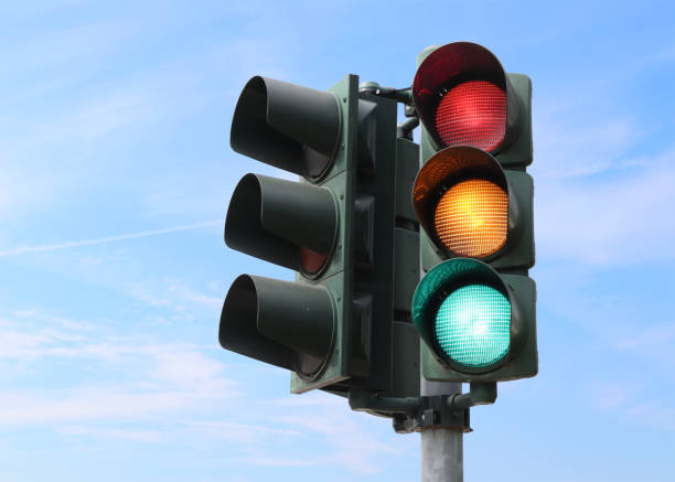 Traffic light isolated in the sky Traffic light isolated in the sky with all the lights on. blue yellow lights stock pictures, royalty-free photos & images