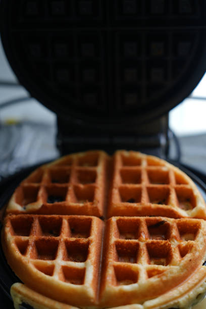 istock Original waffle on the waffle maker.  fresh waffle on waffle maker 2168518026