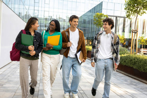 istock Multiracial happy university students walking to class together laughing and talking. Young people in college campus. 2168518471