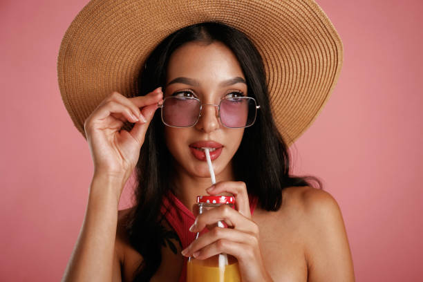 istock Drinking orange juice. Beautiful young woman is against background 2168519655