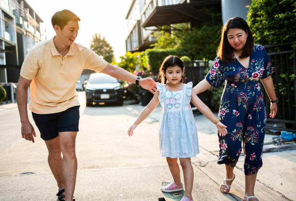 istock Parents helping daughter learn skateboarding on street 2168520140