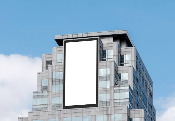istock Mock up white vertical large LED display billboard on tower building with blue sky background .clipping path for mockup 2168522577