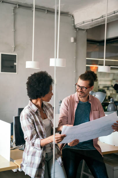istock Diverse group of happy employees analyzing reports together with papers, working together in office 2168530593