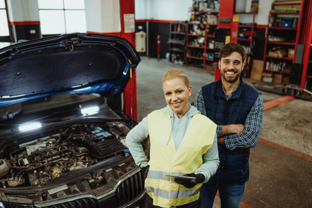 istock Teamwork in car repair shop, technicians fixing the car engine 2168533498