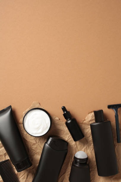 istock Flat lay composition with black cosmetic bottles on brown background. 2168535486