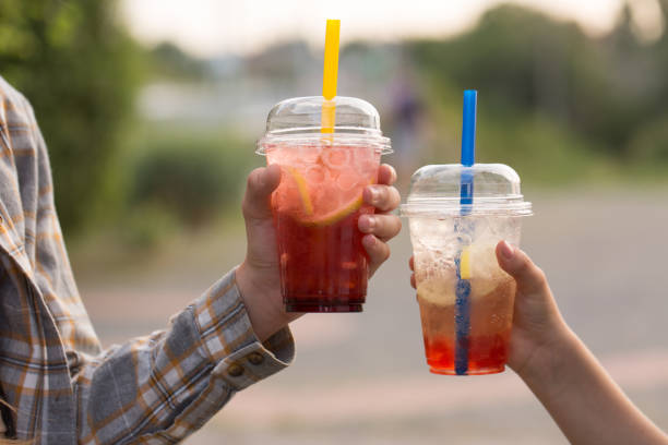 istock Two children drink bubble tea from plastic cups, close-up 2168535928