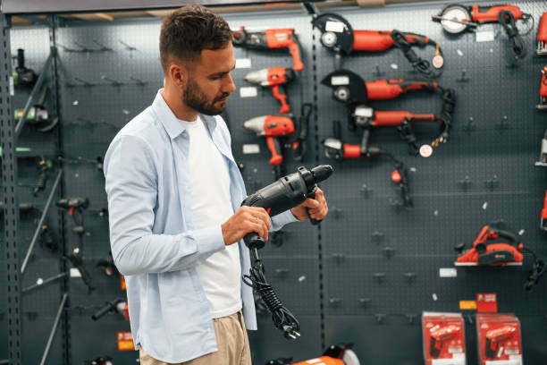 istock Checking the drill. Man is in the hardware shop 2168543510