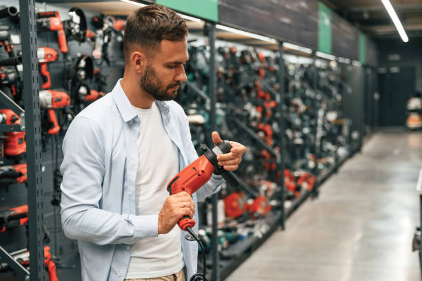istock Checking the drill. Man is in the hardware shop 2168543517